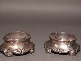 two silver pots sitting next to each other on a table