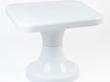 a small white table with a square top on a white background