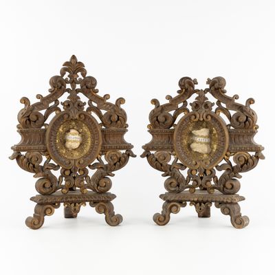 pair of antique brass clock stands with ornate carvings on each of them