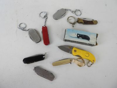 de nombreux types de couteaux et de porte-clés posés sur la table