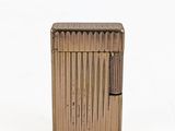 an image of a gold lighter sitting on top of a white surface