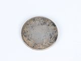 a close up of a silver coin on a white surface