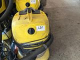 yellow vacuum cleaners are lined up on the floor in a garage