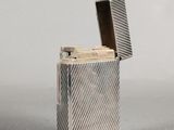 an image of a silver lighter sitting on top of a table