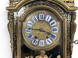 a gold clock with roman numerals on the face