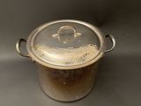 a metal pot with a lid on a table