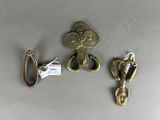 three pieces of brass are sitting on a table next to each other