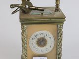 a small clock with a key on top of it