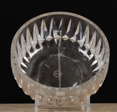 a clear glass bowl on a wooden table with a black background
