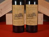 two bottles of wine sitting next to each other on a table
