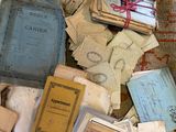 a pile of old books on the floor next to a pile of papers