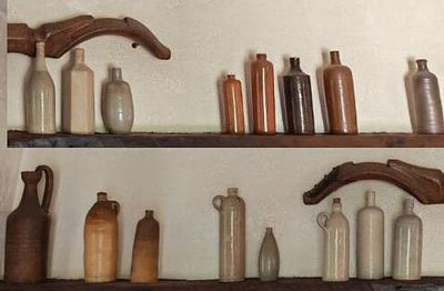 de nombreuses bouteilles et vases sur les étagères de la pièce