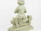 statue of a woman sitting on a bench with her back to the camera