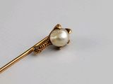 gold plated stick pin with a pearl bead on a white background