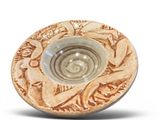 a small bowl with a design on it on a white surface