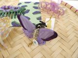 a purple butterfly brooch on a table next to a purple comb