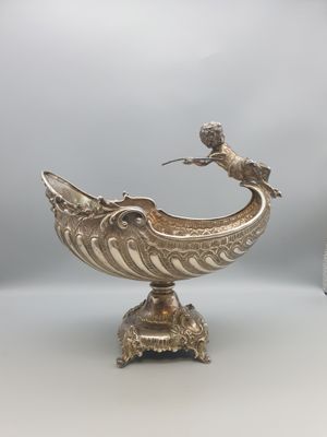 un bol en argent surmonté d'un oiseau