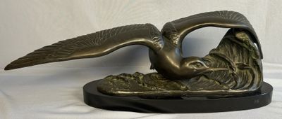 a bronze statue of a bird on a black base