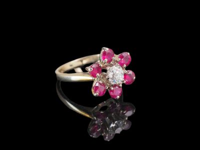 un gros plan d'une bague sertie d'un diamant rose et blanc sur une surface noire