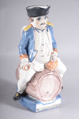 une figurine représentant un homme assis sur un tonneau