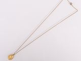 gros plan d'un collier en or sur une surface blanche