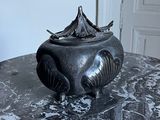 a black vase on a marble table with a door in the background