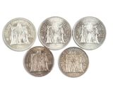 six pièces de monnaie britanniques différentes posées sur une surface blanche, sur fond blanc