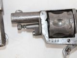 two old revolvers sitting on a table next to each other