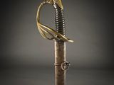 a close up of a sword with a gold handle on a black background