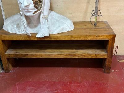 une statue représentant un homme assis sur un banc en bois