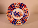 an orange and blue plate with flowers on it sitting on a table
