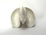 a small white bowl with a toothbrush inside of it