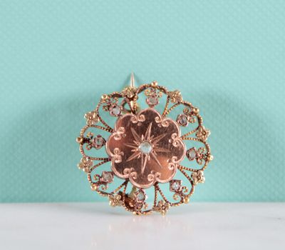 un gros plan d'une broche en or posée sur une table