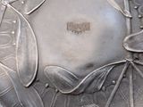 a close up of a silver plate with a flower design on it