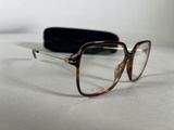 glasses on a white surface with a black case in the background