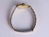 a silver bracelet with a gold clasp on a white surface