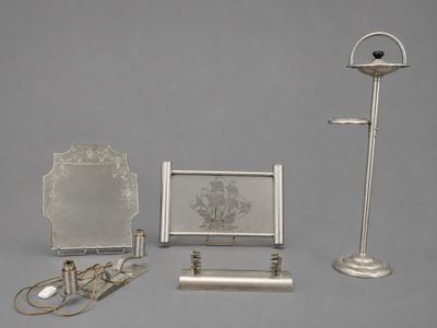 three silver objects that are on display on a gray surface