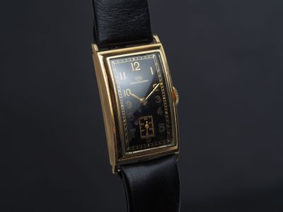 gros plan d'une montre sur une surface noire avec un fond noir
