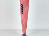 pink and black vase on a black stand on a white surface