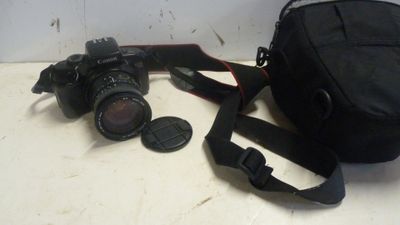un appareil photo et un sac posés l'un à côté de l'autre sur une table