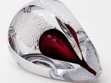 a glass heart shaped object on a white surface