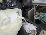 a pile of garbage sitting on the floor in a cluttered room