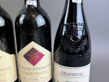 three bottles of wine are lined up in a row on a table