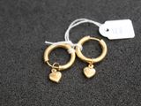 une paire de boucles d'oreilles créoles en or ornées de pendentifs en forme de cœur