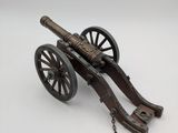 an antique cast iron cannon with chain on a white background
