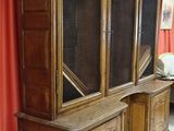 a large wooden cabinet in a room with a red curtain