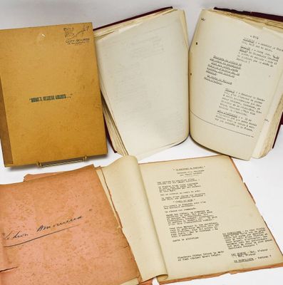 trois livres ouverts posés sur une table l'un à côté de l'autre