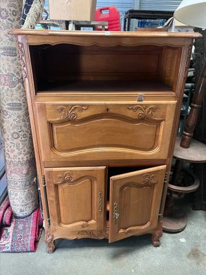 une armoire en bois à deux portes, avec un tiroir en dessous