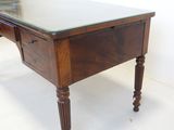a desk with a glass top and wooden legs
