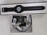 a black and white picture of a watch and a charger
